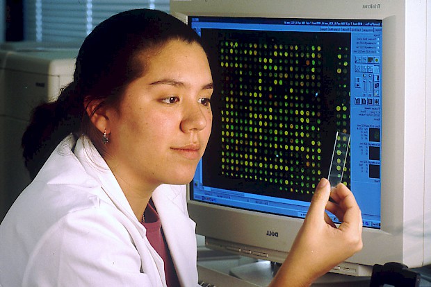 Laborantin vor einem Rechner mit DNA-Test. Abbildung: Bill Branson; gemeinfrei; https://commons.wikimedia.org/wiki/File:Computer_with_microarray.jpg